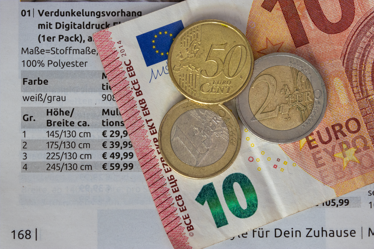Moedas de euro sobre um mapa da Europa com calculadora ao lado.