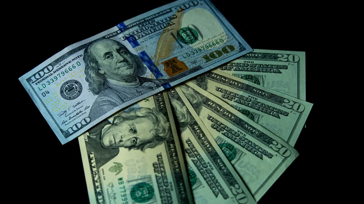 Notas de dólar americano espalhadas sobre uma superfície