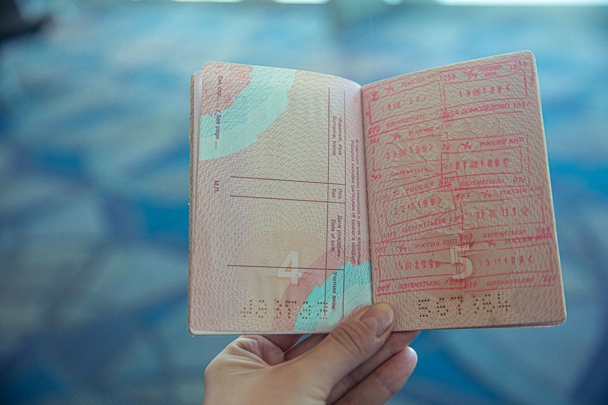 Passaporte e cédulas de dólar sobre a mesa de atendimento do aeroporto.