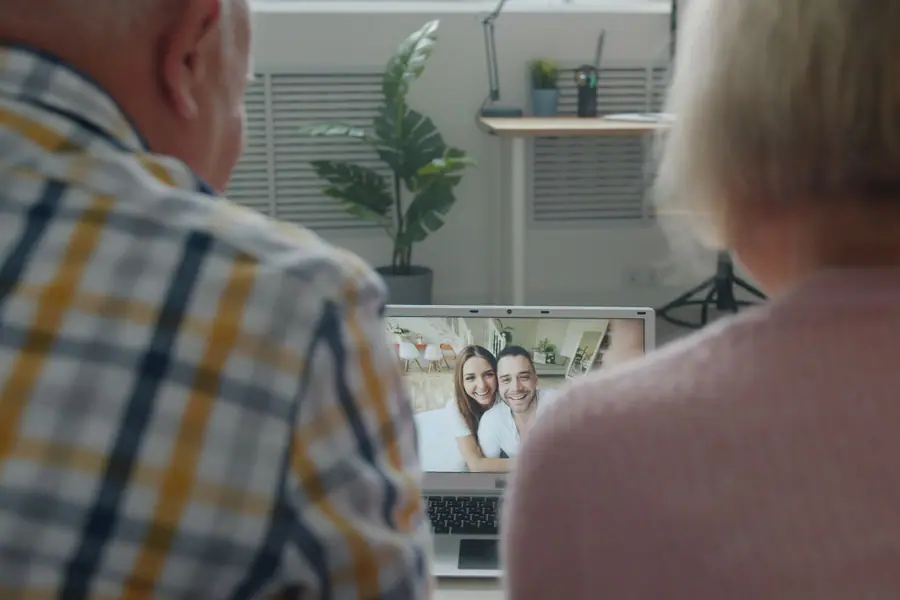 Casal de idosos fazendo uma chamada de vídeo com a família em um notebook Casal de idosos fazendo uma chamada de vídeo com a família em um notebook