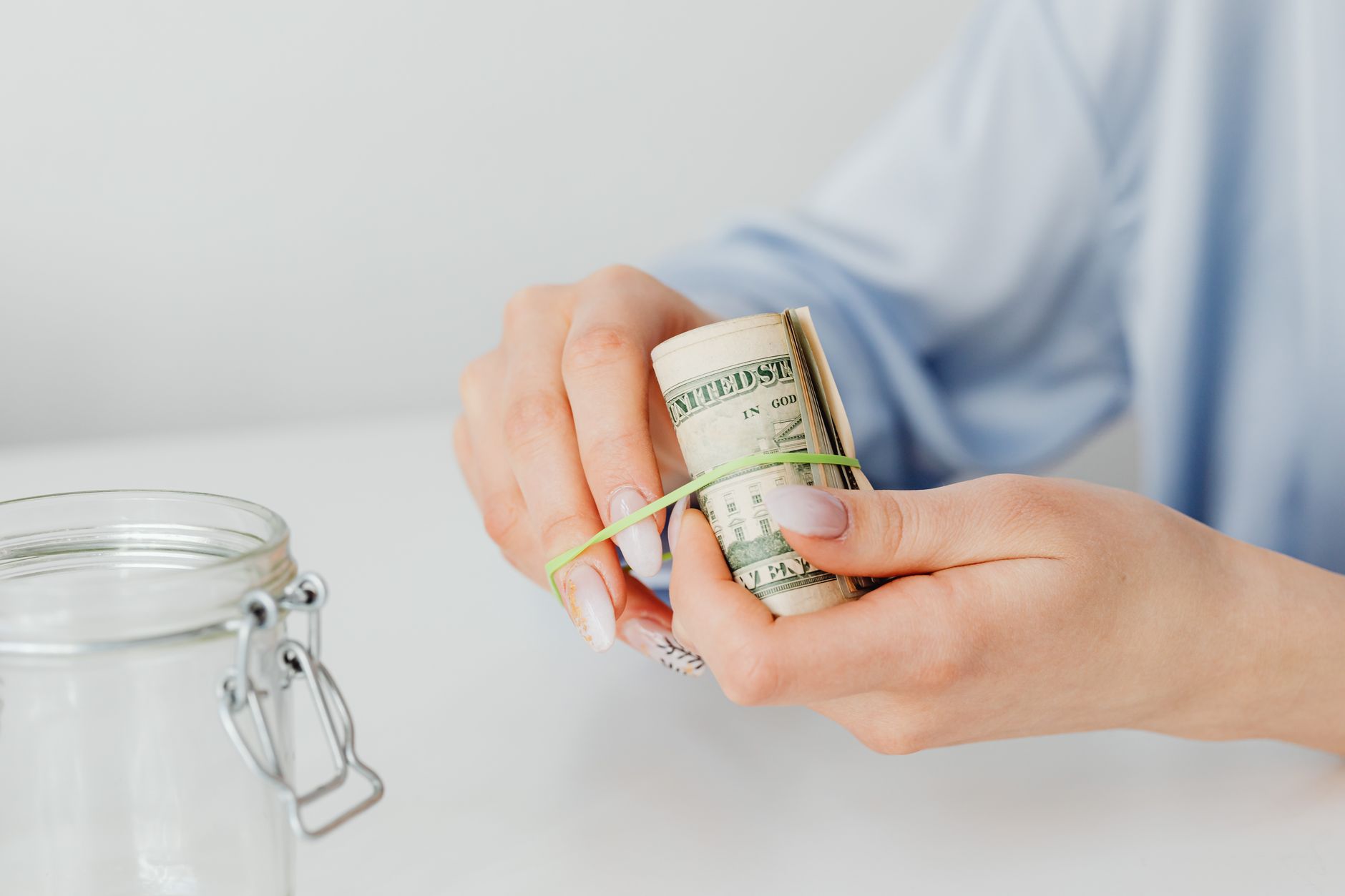 Pessoa analisando nota de dólar contra a luz em mesa de escritório.