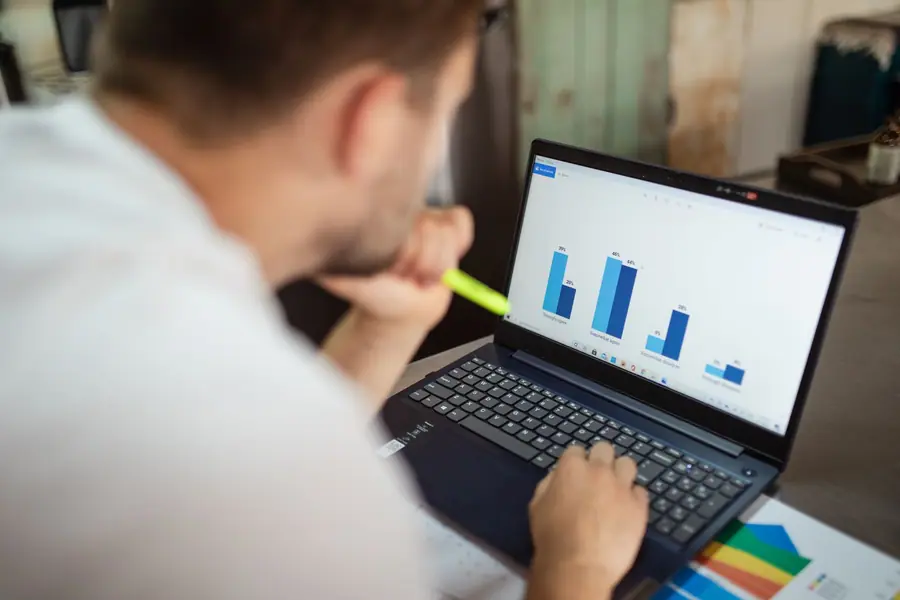 Profissional analisando gráficos financeiros em um notebook Profissional analisando gráficos financeiros em um notebook