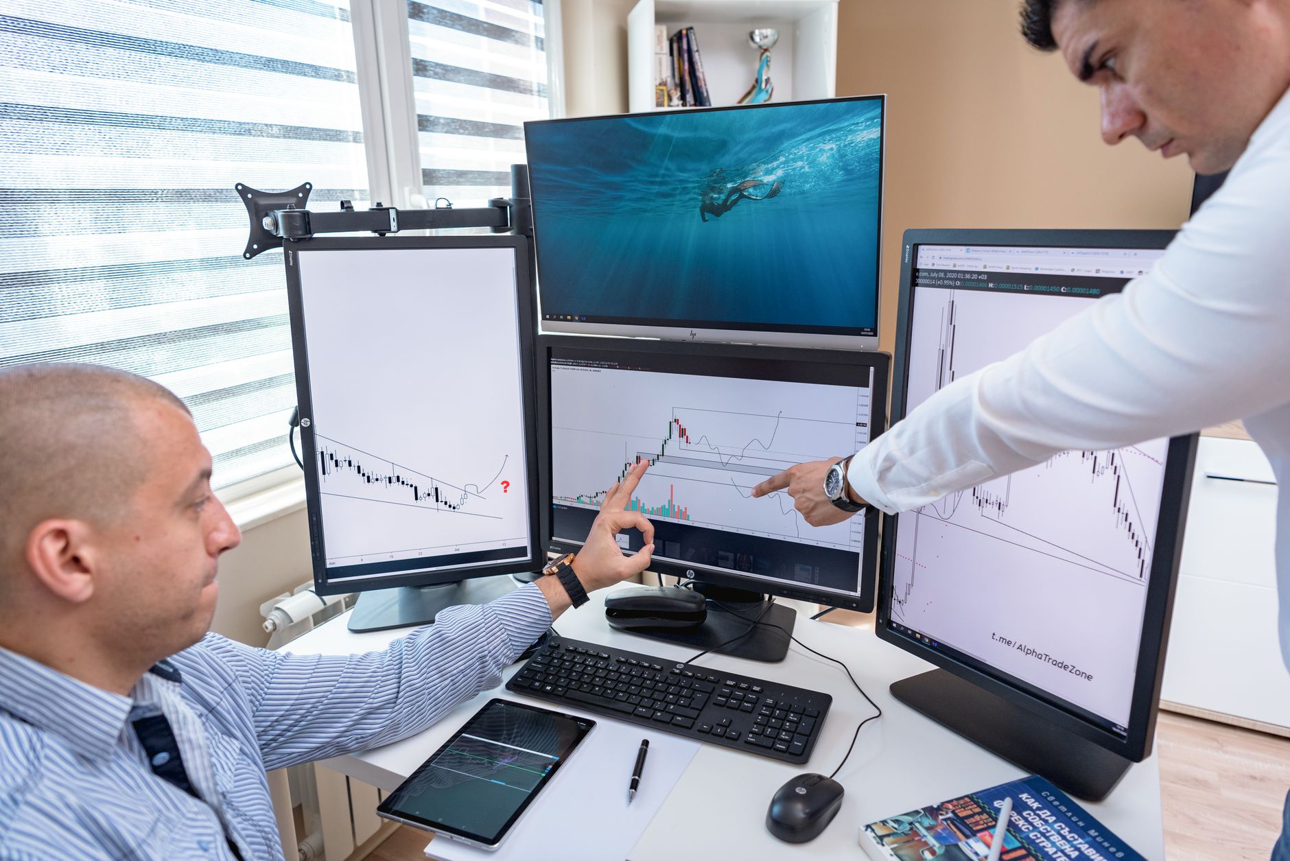 Pessoa analisando relatórios gráficos e cotações financeiras em um computador.