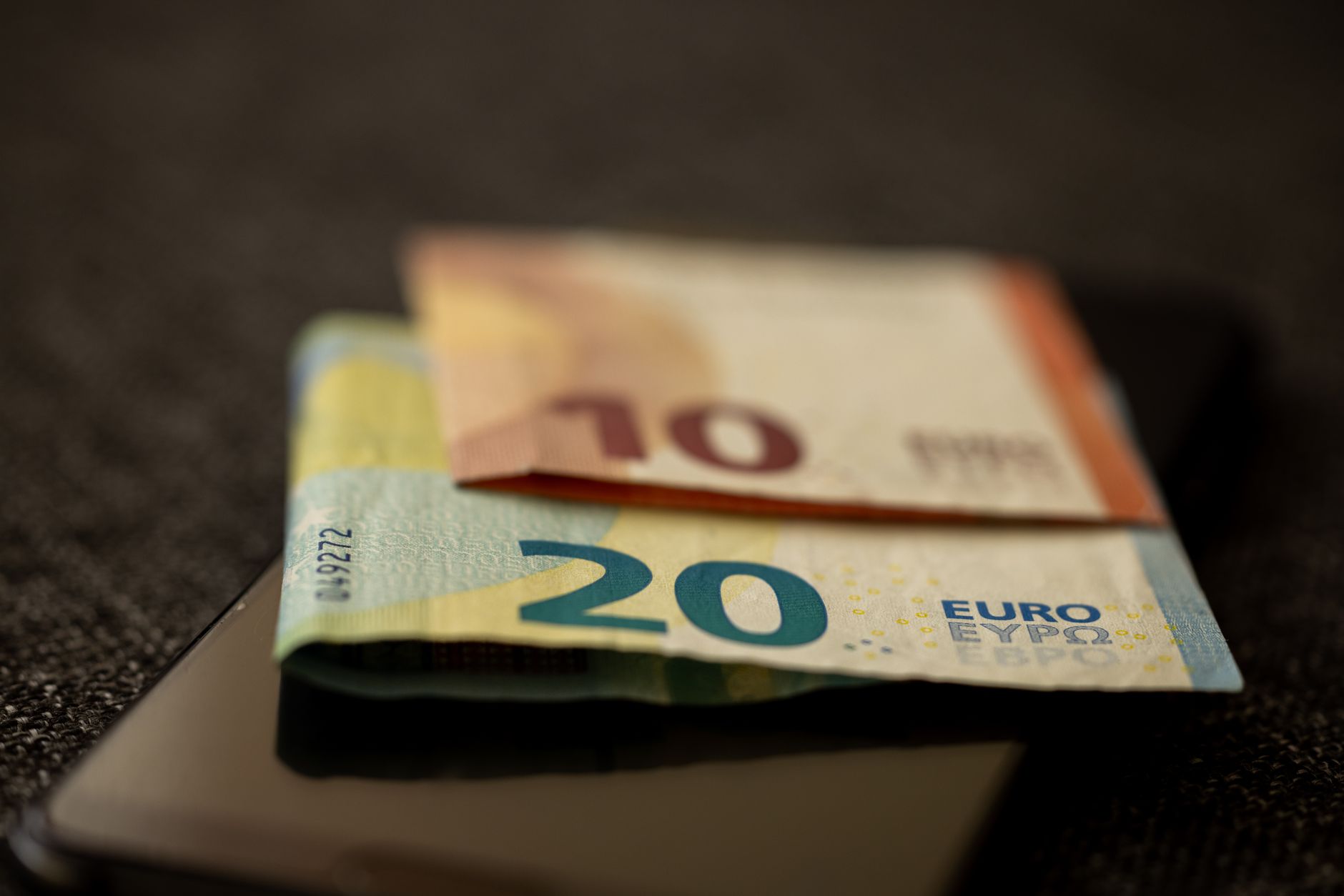Pessoa segurando celular mostrando aplicativo bancário de conta internacional em euro.