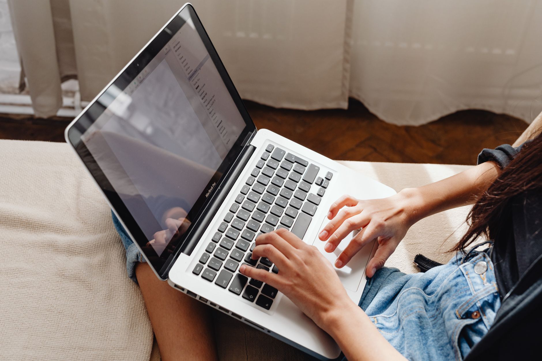 Pessoa analisando documentos financeiros com um laptop ao lado.