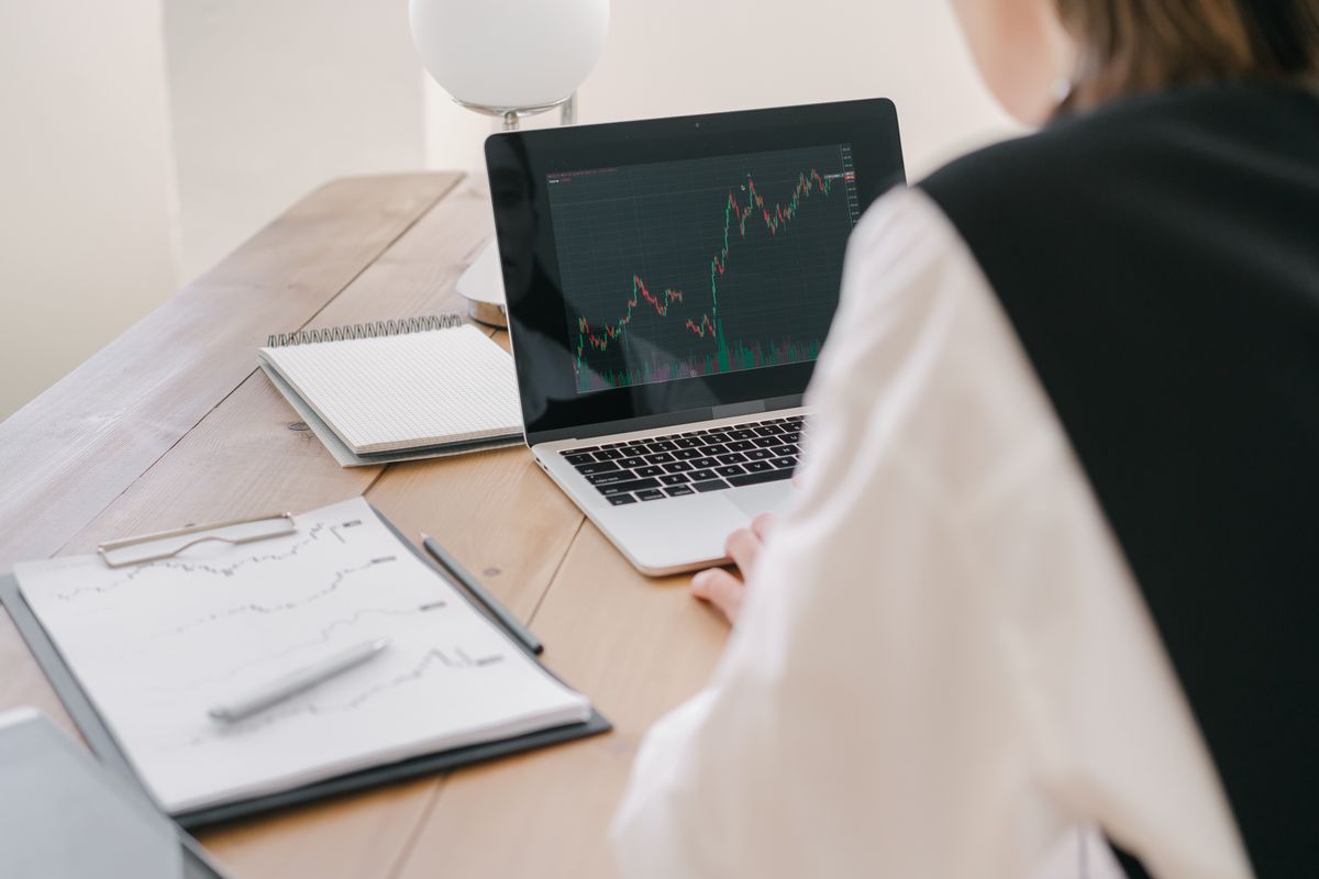 Pessoa acompanhando gráficos de cotação do dólar na tela do computador.