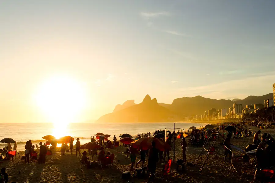 Pôr do sol na praia de Ipanema com banhistas e movimento Pôr do sol na praia de Ipanema com banhistas e movimento