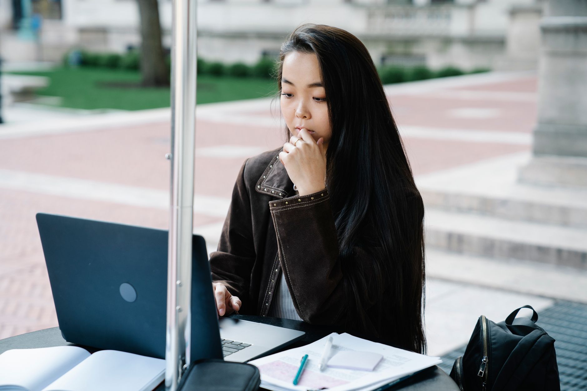 Estudante universitário usando laptop e smartphone em um café na Europa
