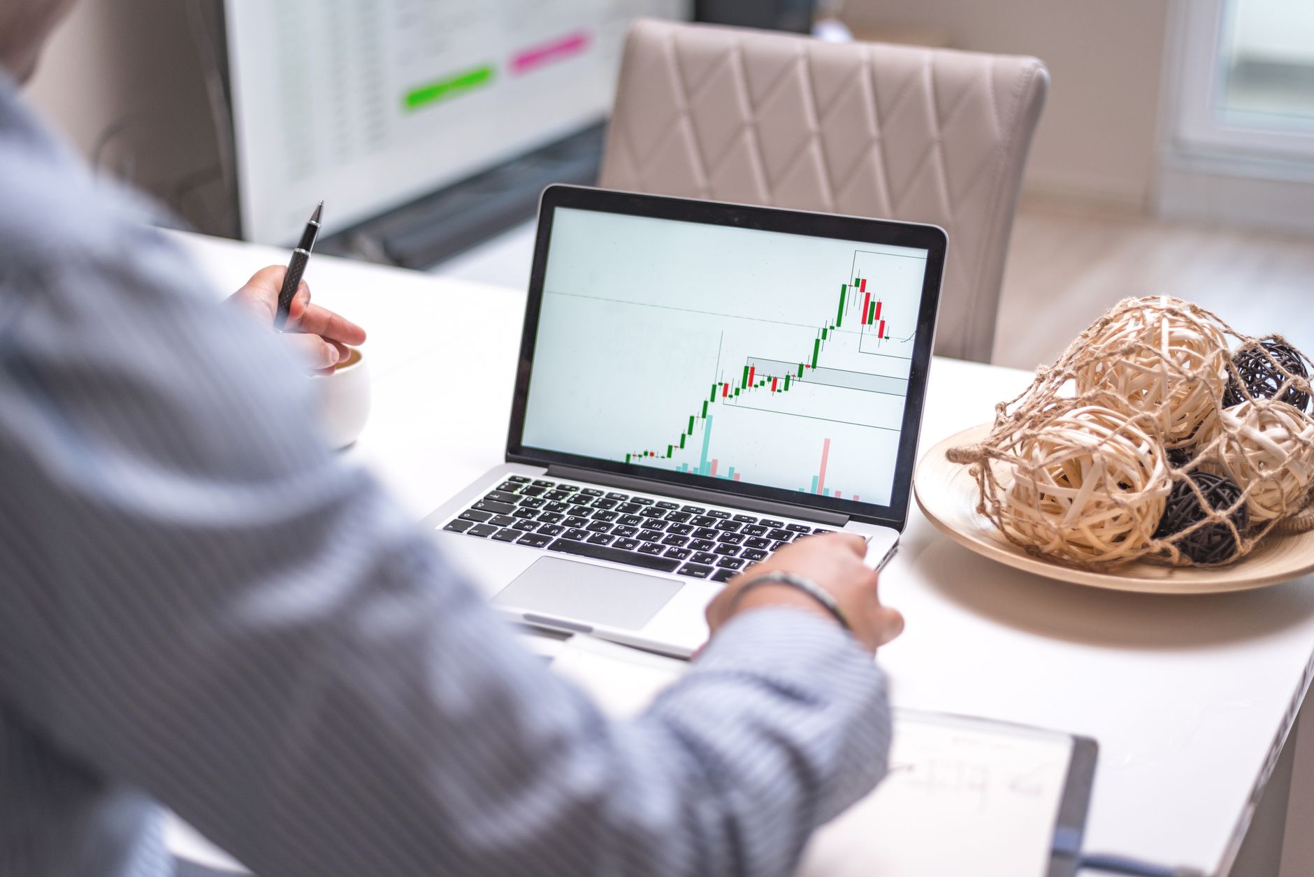 Pessoa analisando gráficos financeiros em um computador.