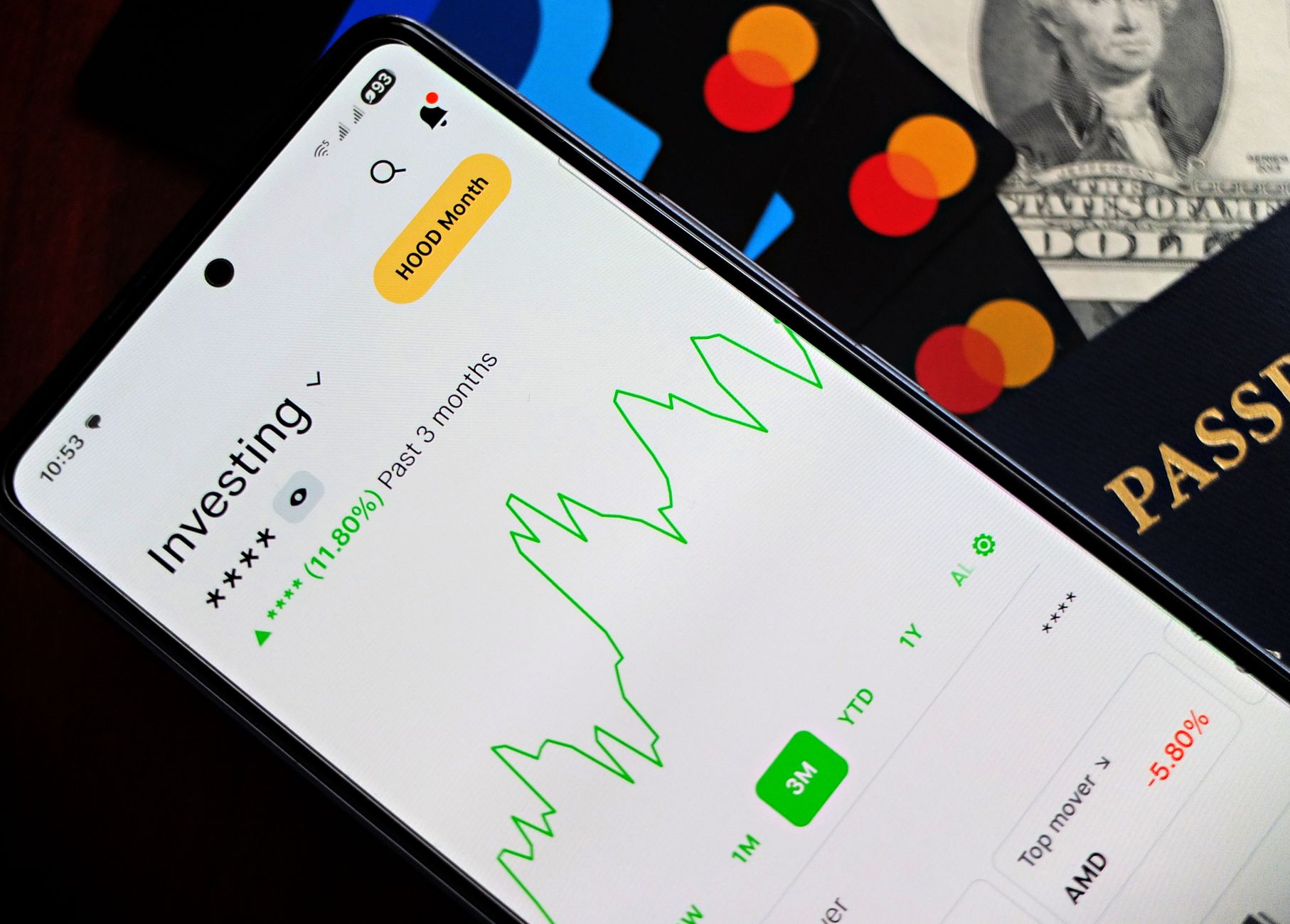 Entenda a diferença entre Euro à vista e Euro Futuro A smartphone showing an investment app with green growth indicators, surrounded by credit cards, US dollars, and a passport.