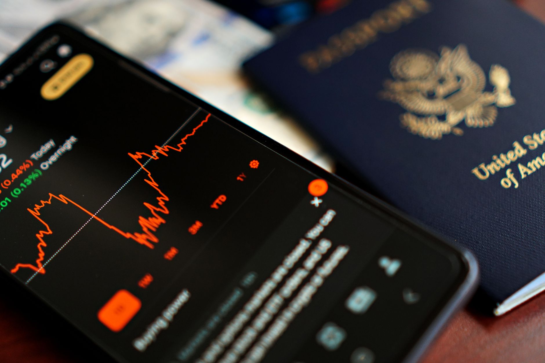 Pessoa analisando a cotação do euro ao lado de um passaporte e documentos de viagem