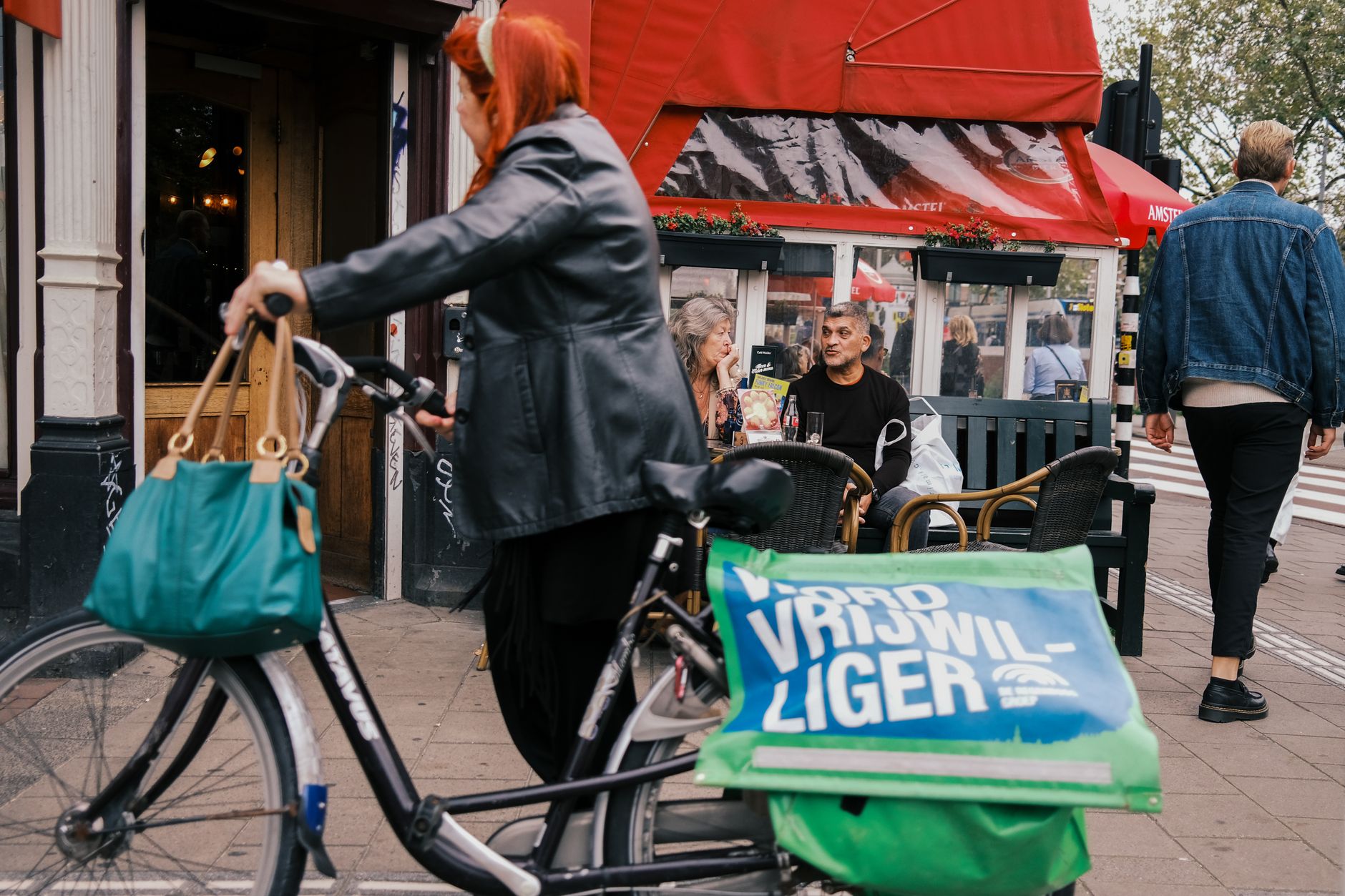 Euro na Holanda: dinheiro e cartão Cozy outdoor café setting in Amsterdam with people enjoying coffee and a nearby parked bicycle.
