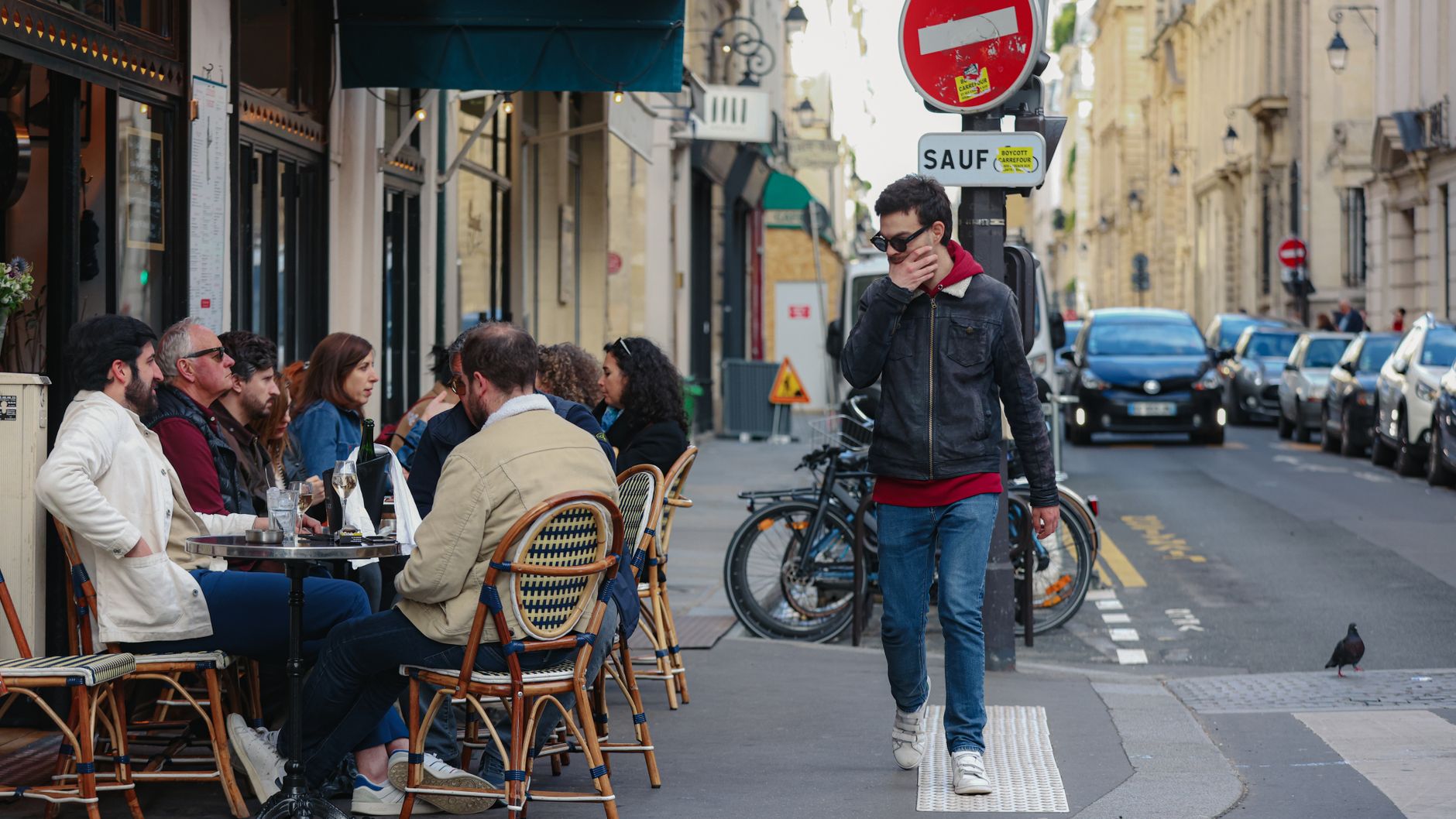 People enjoying a leisurely afternoon at a Parisian café, showcasing vibrant street life.