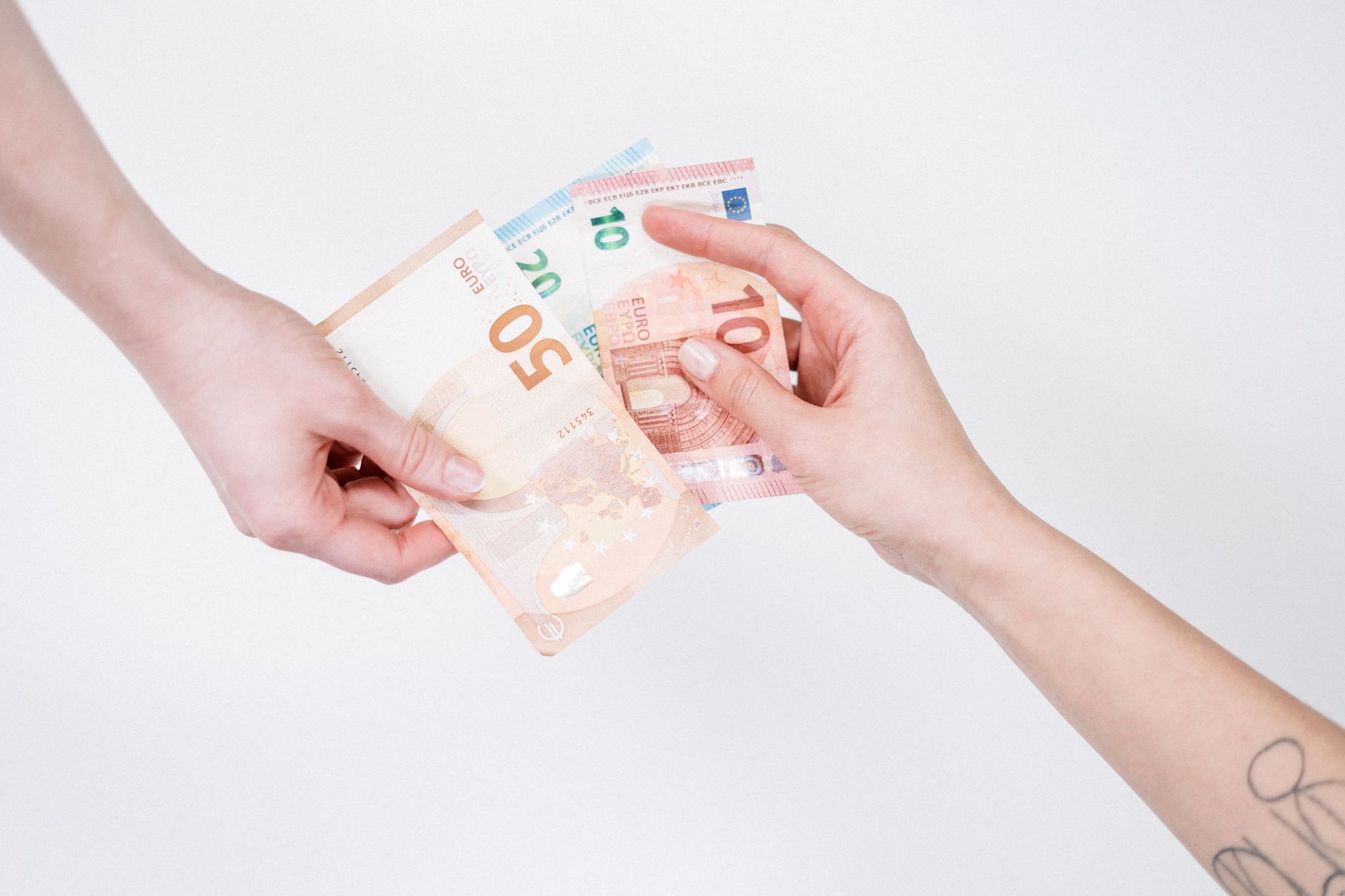 Viajante organizando notas de euro e documentos sobre uma mesa antes de viajar para Portugal