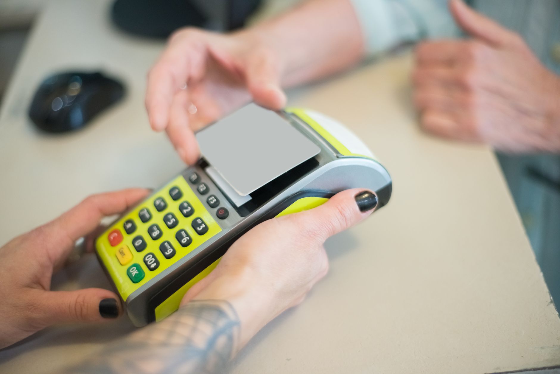 Euro em Portugal: como funciona o dinheiro na sua viagem Hands engaging in a secure card transaction with a payment terminal, capturing the essence of modern business transactions.