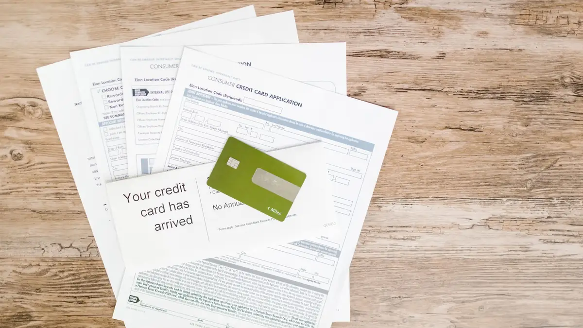 Cartão de crédito e documentos de solicitação sobre uma superfície de madeira
