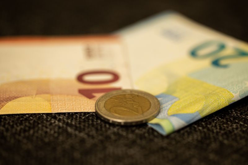 Hedge com opções de dólar: pessoa física pode usar? Detailed close-up of Euro banknotes and coin, showcasing European currency likeness.