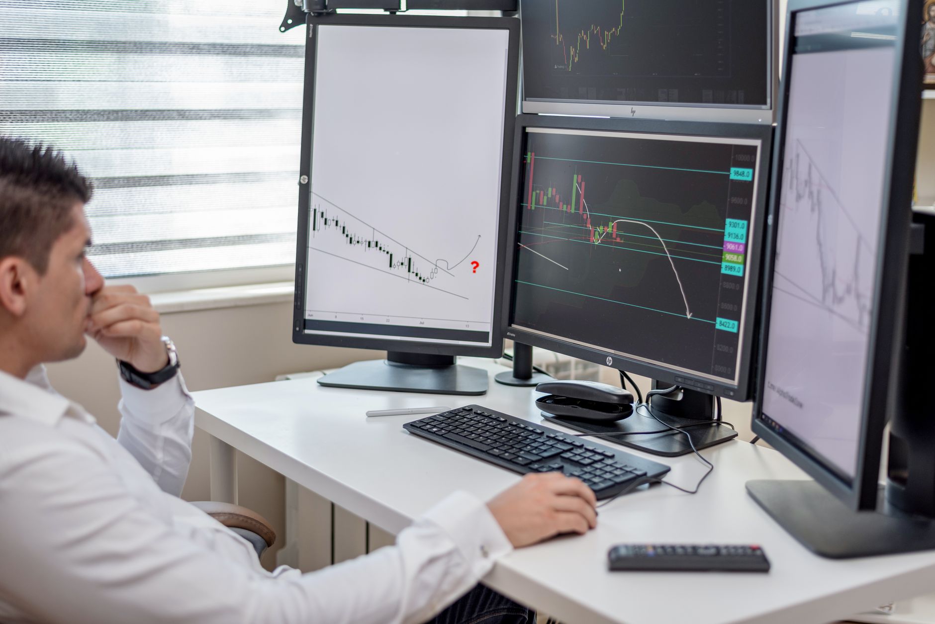 Como a Inflação Europeia Influencia o Euro? Business professional analyzing financial data on multiple computer monitors at his workspace.