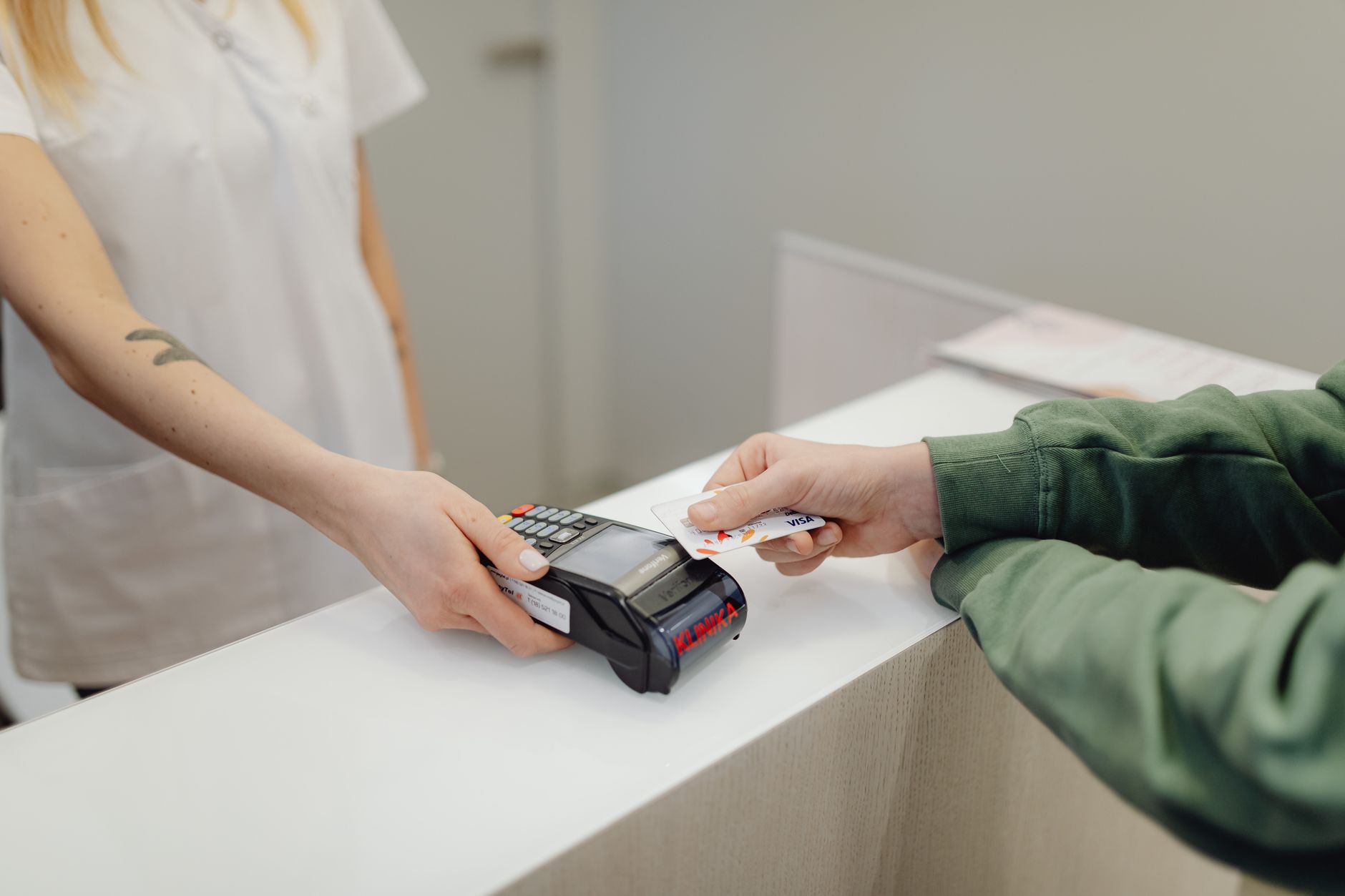 NDF de moeda: o que é o contrato a termo e quem pode usar Person using a bank card for contactless payment at a modern checkout counter.
