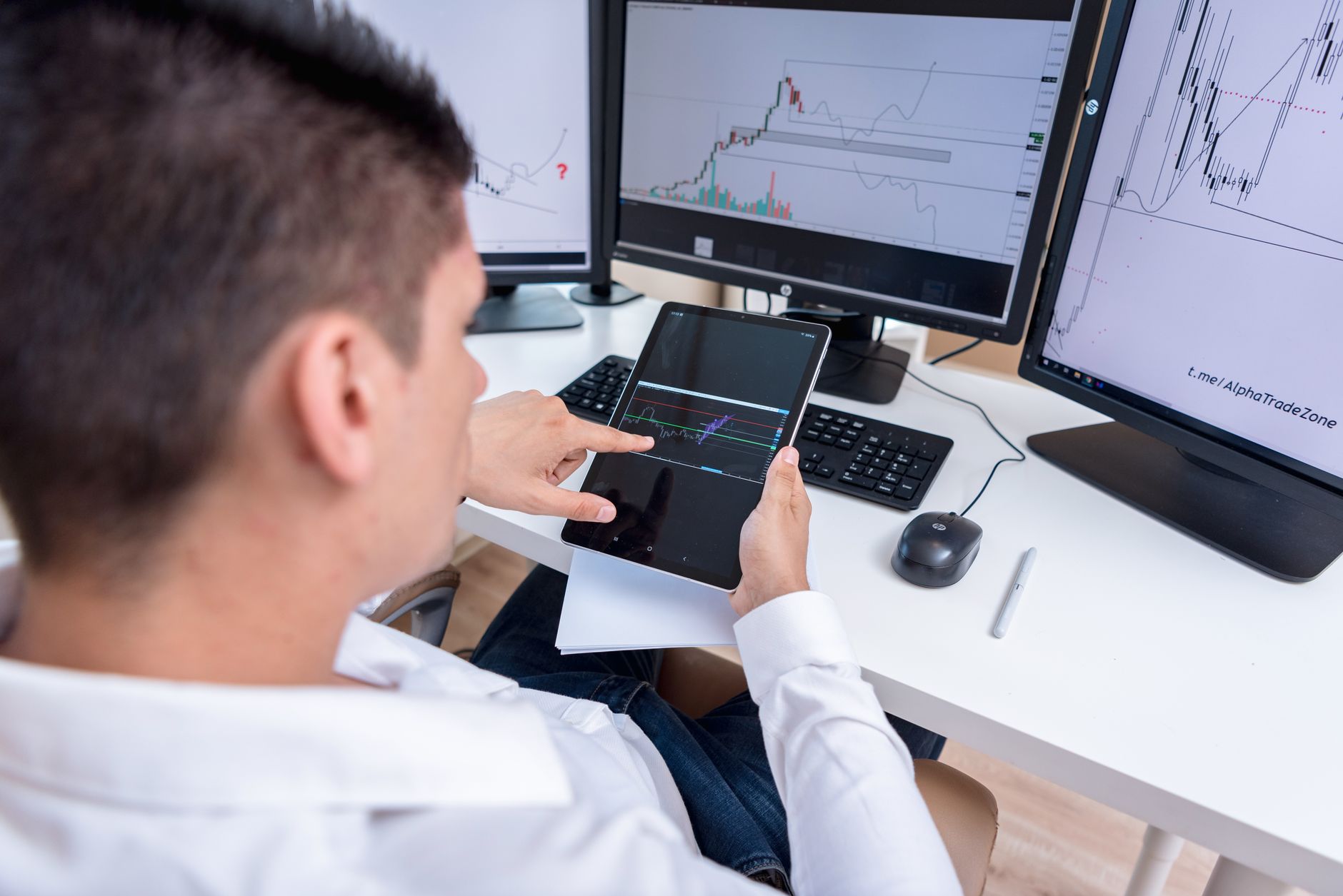O que é o índice DXY e como ele mede o dólar A stock trader analyzing cryptocurrency charts on multiple monitors and a tablet.