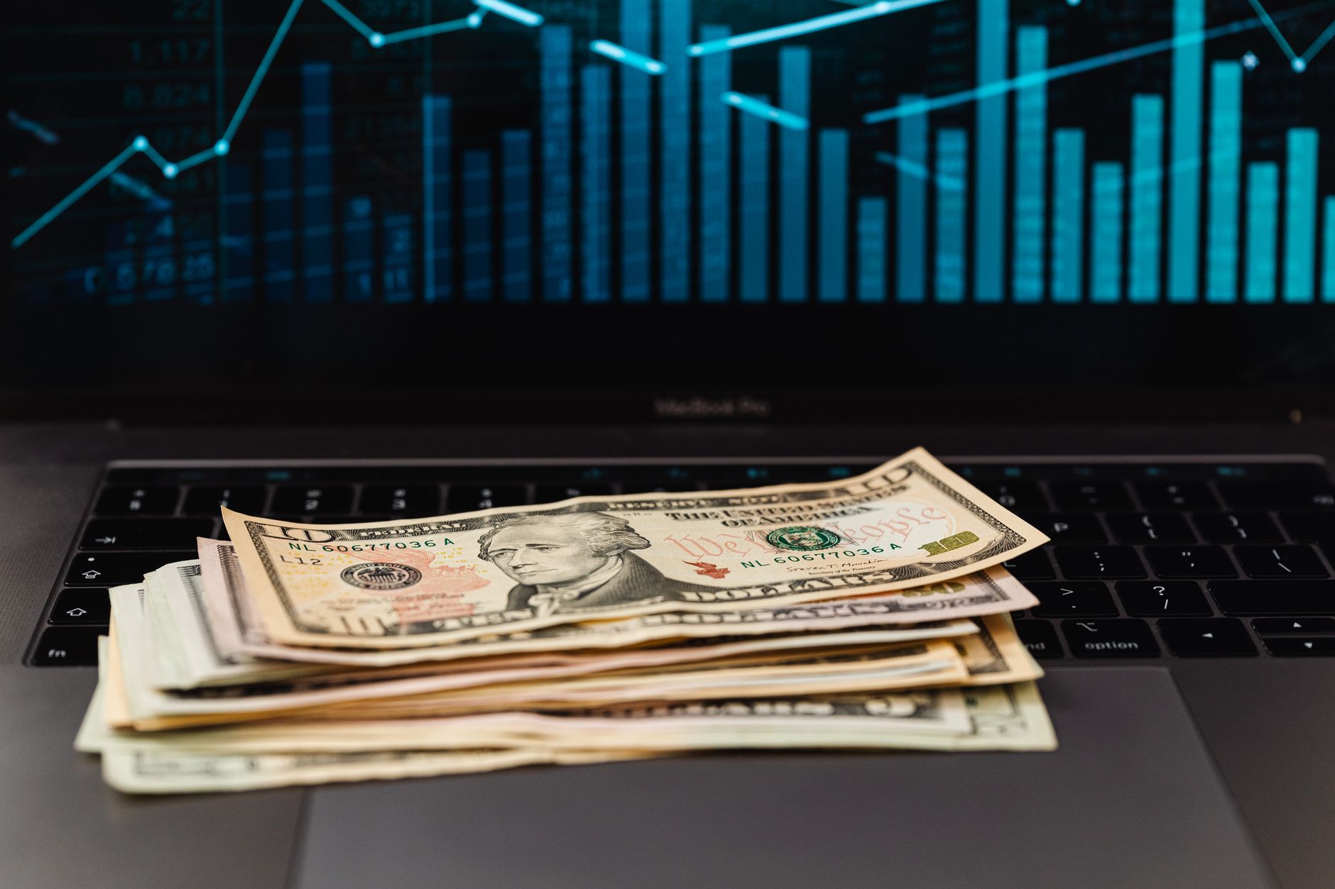 Pessoa analisando investimentos e cotações em dólar diante de um notebook