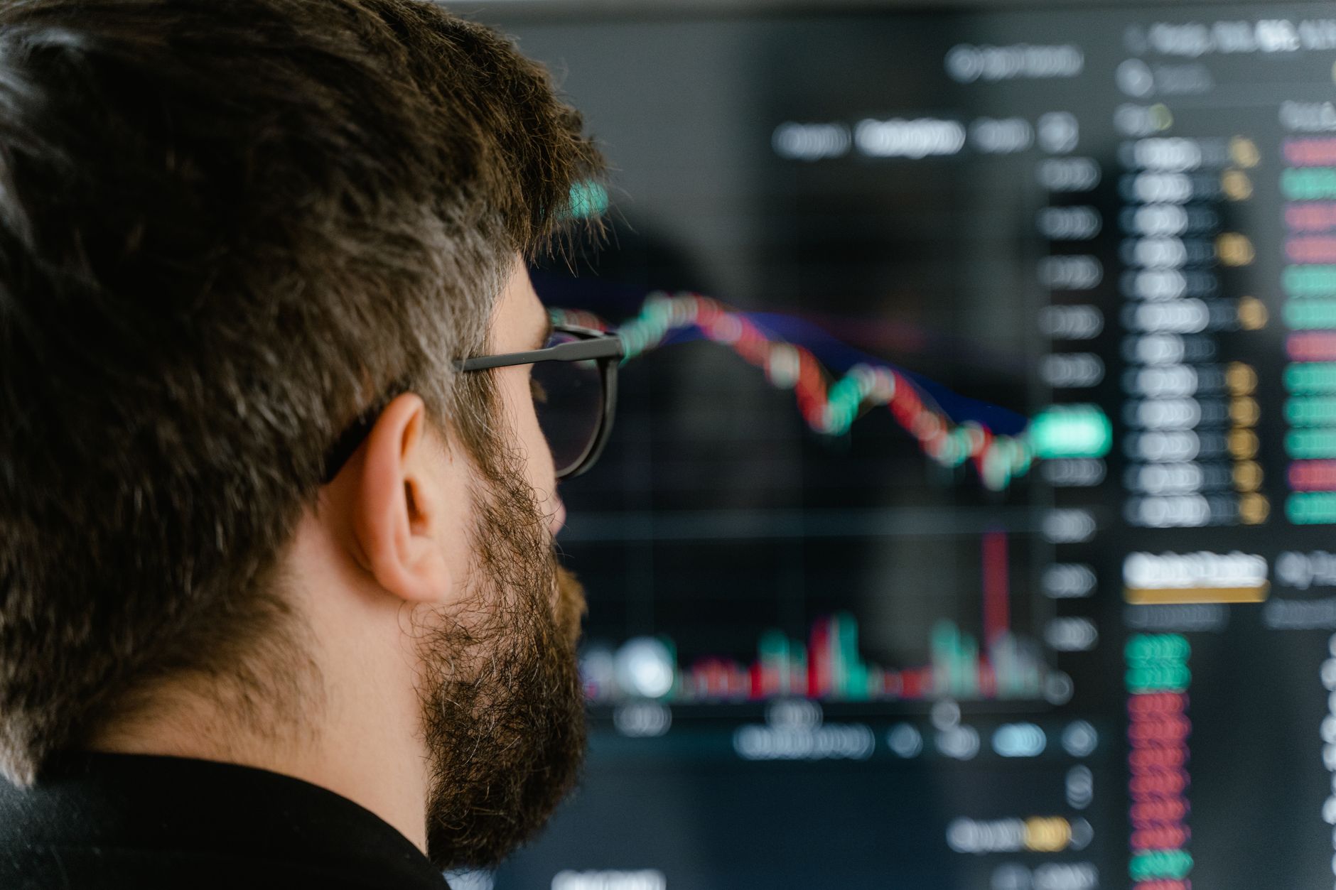 Pessoa analisando gráficos financeiros e cotações de empresas estrangeiras em um computador.