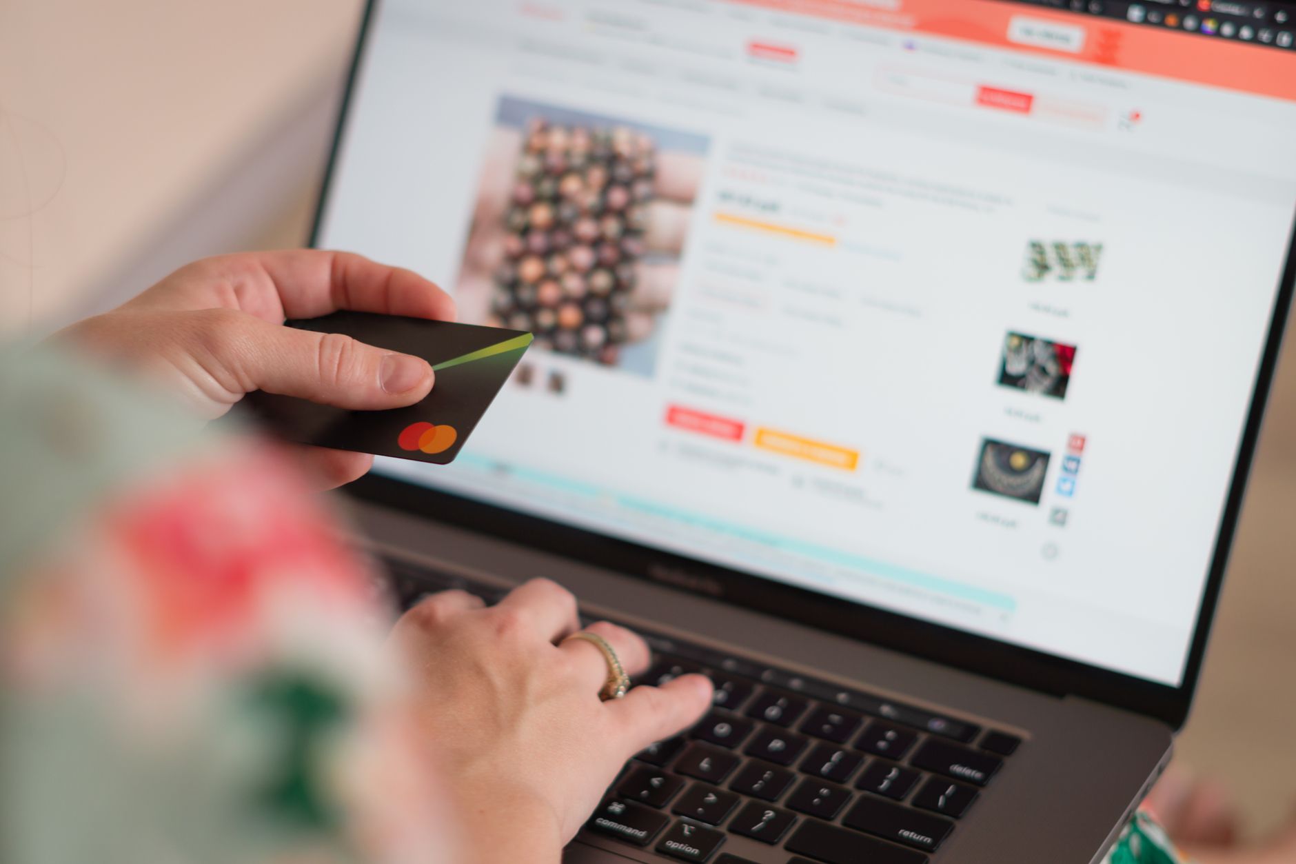 Pessoa usando cartão de crédito para fazer compras em um computador portátil