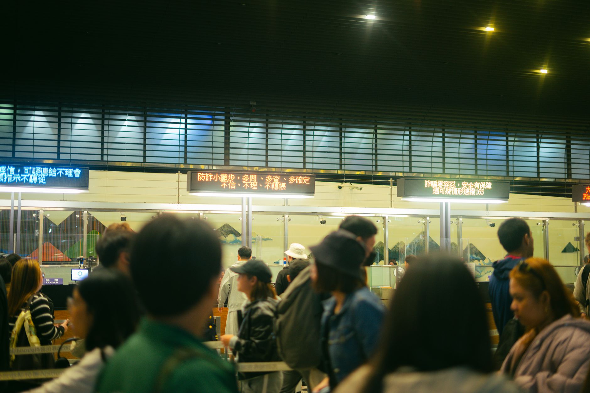 Quais países adotam o euro como moeda oficial Crowded airport check-in area with people queueing and visible flight information signs.