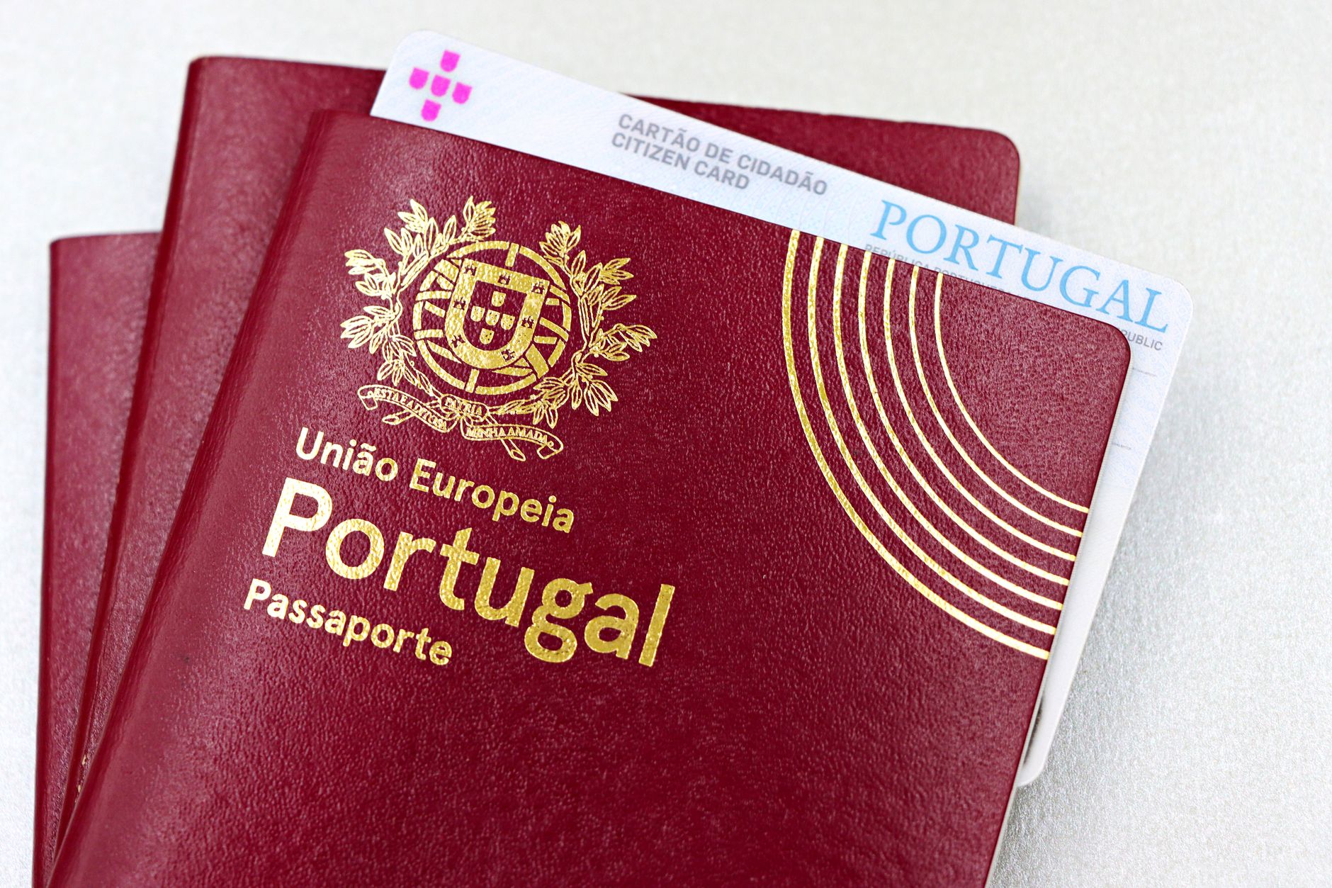 Pessoa organizando passaporte, extratos bancários e documentos de viagem sobre uma mesa