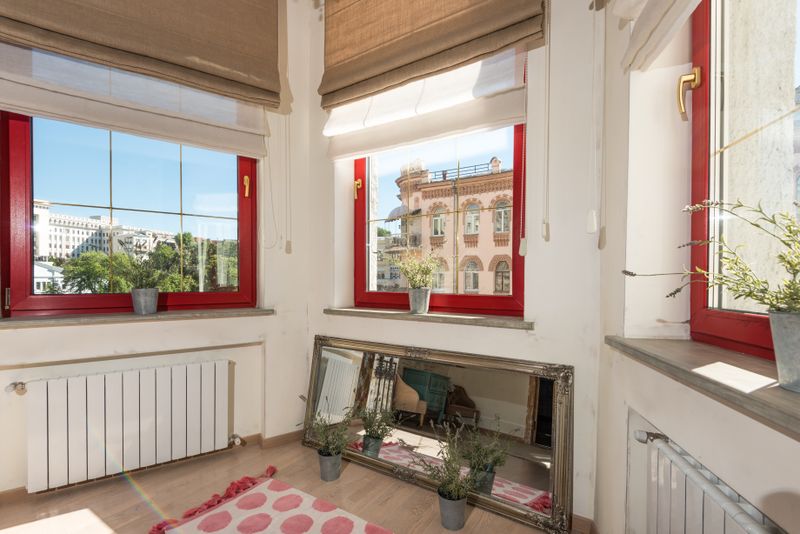 Quanto Custa Luz, Água e Gás na Europa? Entenda as Despesas Bright apartment interior showcasing red windows overlooking the city.