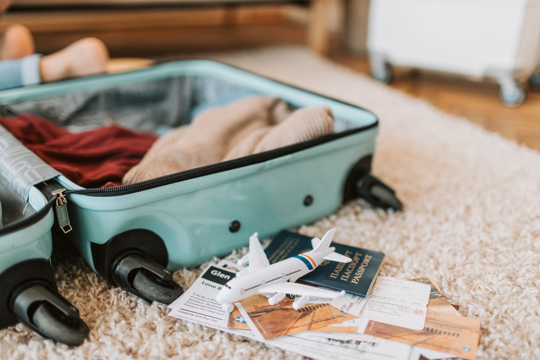 Casal jovem organizando documentos de viagem e passaportes sobre uma mesa com notas de euro ao planejar a mudança.