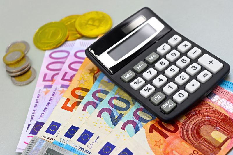Quanto Custa Creche e Escola na Europa? Veja Como Funciona Image of euro banknotes, coins, and a calculator for financial planning. Perfect for finance themes.