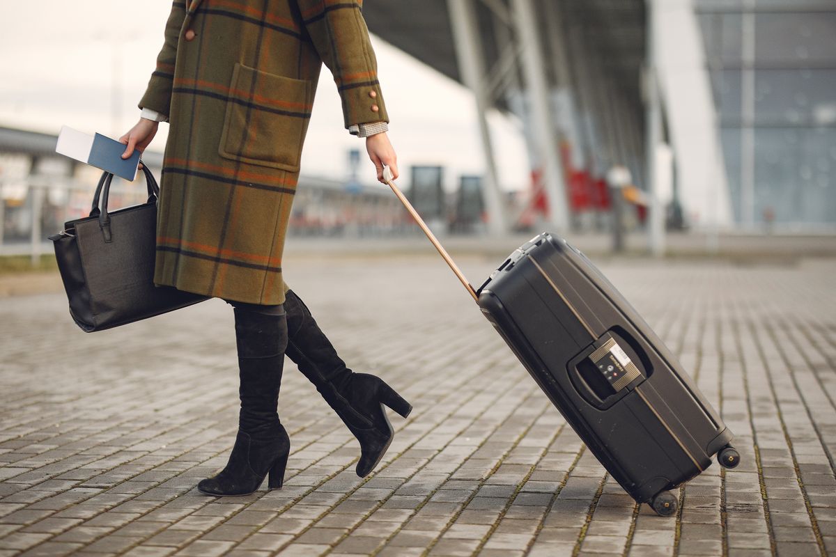 Profissional de negócios segurando passaporte e cartão de crédito em um aeroporto europeu.