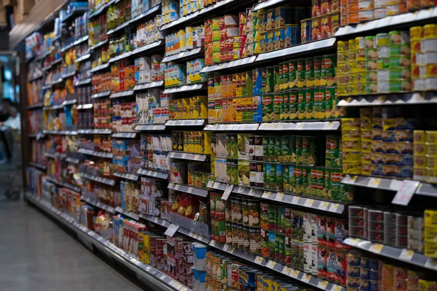 Corredor de supermercado com prateleiras de produtos enlatados Corredor de supermercado com prateleiras de produtos enlatados