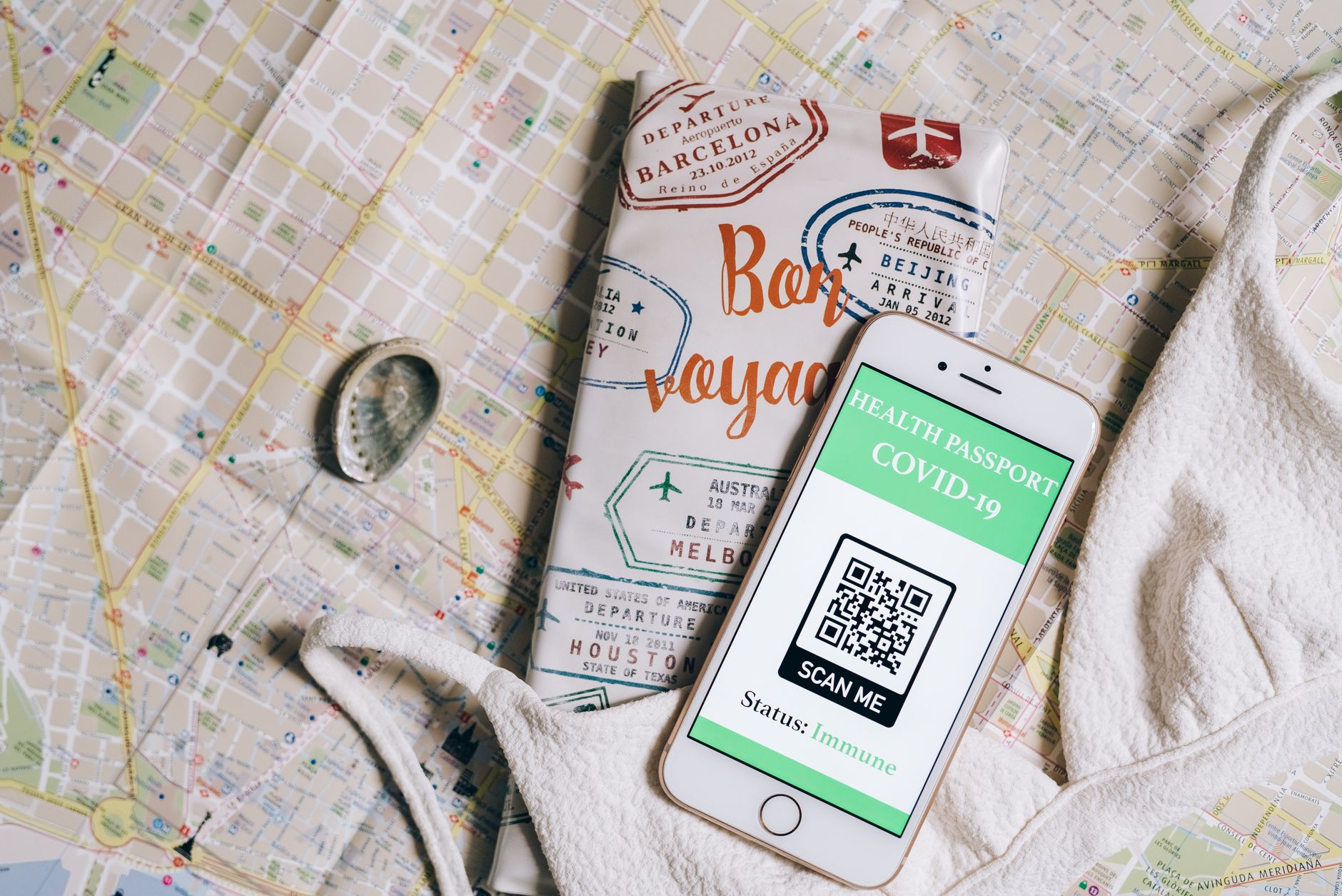 Pessoa conferindo o celular e documentos financeiros antes de uma viagem internacional
