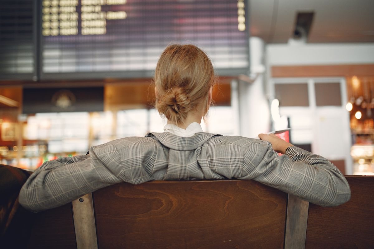 Viajante observando painel de voos em terminal de aeroporto na Europa