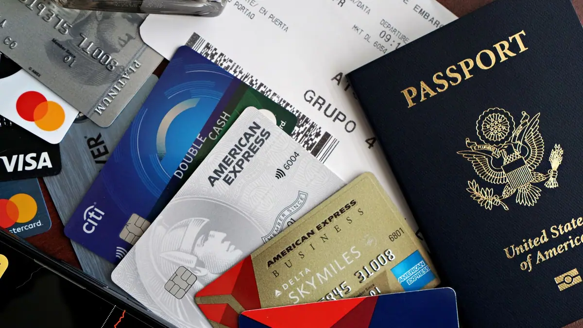 Passaporte, cartões e cartão de embarque organizados sobre uma mesa