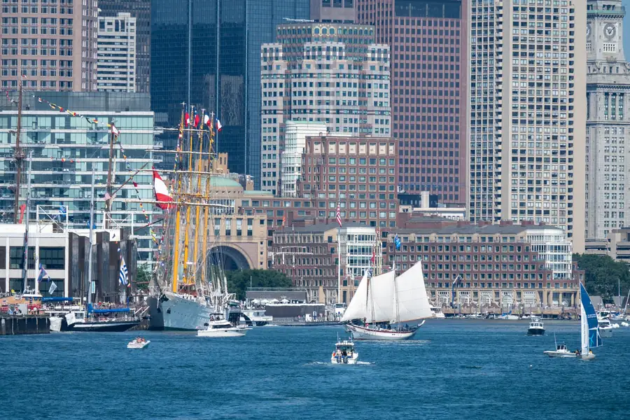 Barcos e prédios da região portuária de Boston ao entardecer