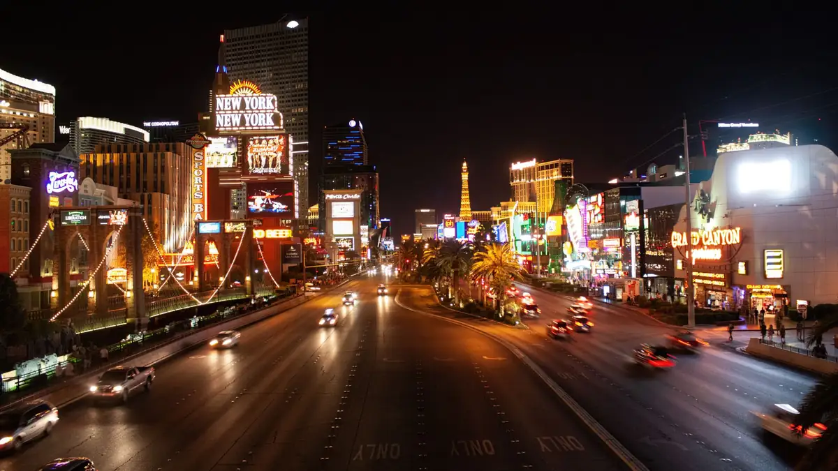 Avenida principal de Las Vegas iluminada à noite com hotéis e luzes de neon