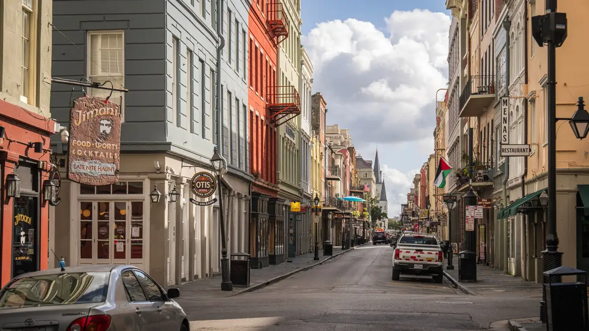 Rua do French Quarter em Nova Orleans com varandas de ferro e bandeiras