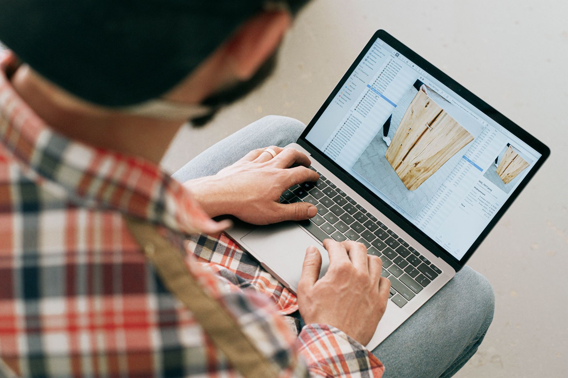 Nota fiscal de serviço eletrônica: guia para emitir A craftsman uses a laptop to design wooden furniture in a workshop setting.