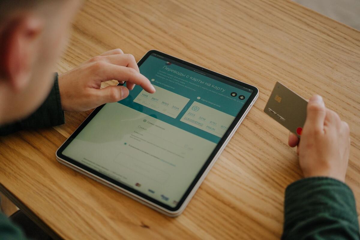 Pessoa fazendo pagamento online com tablet e cartão