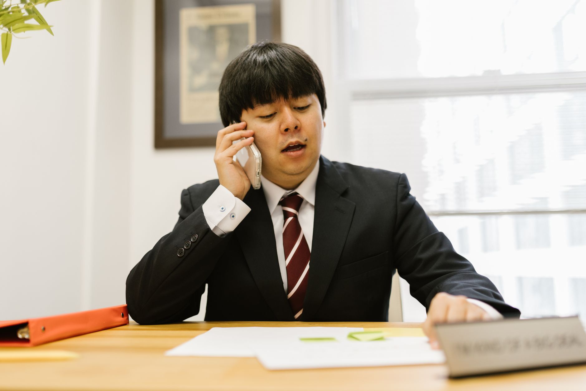 Como consultar se um CPF está negativado Asian businessman in black suit talking on phone at desk in office