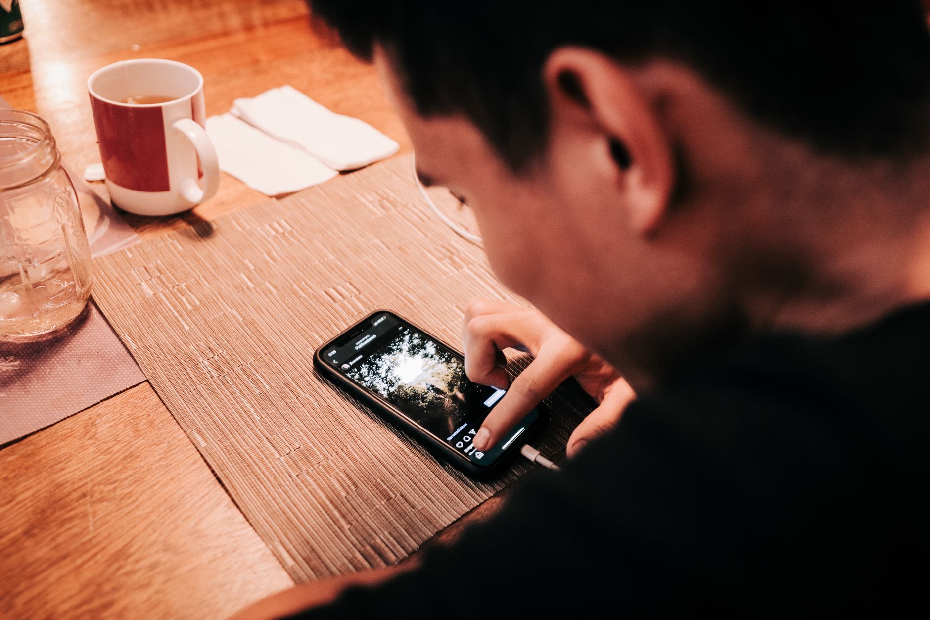 Pessoa consultando informações do benefício em um celular sobre a mesa