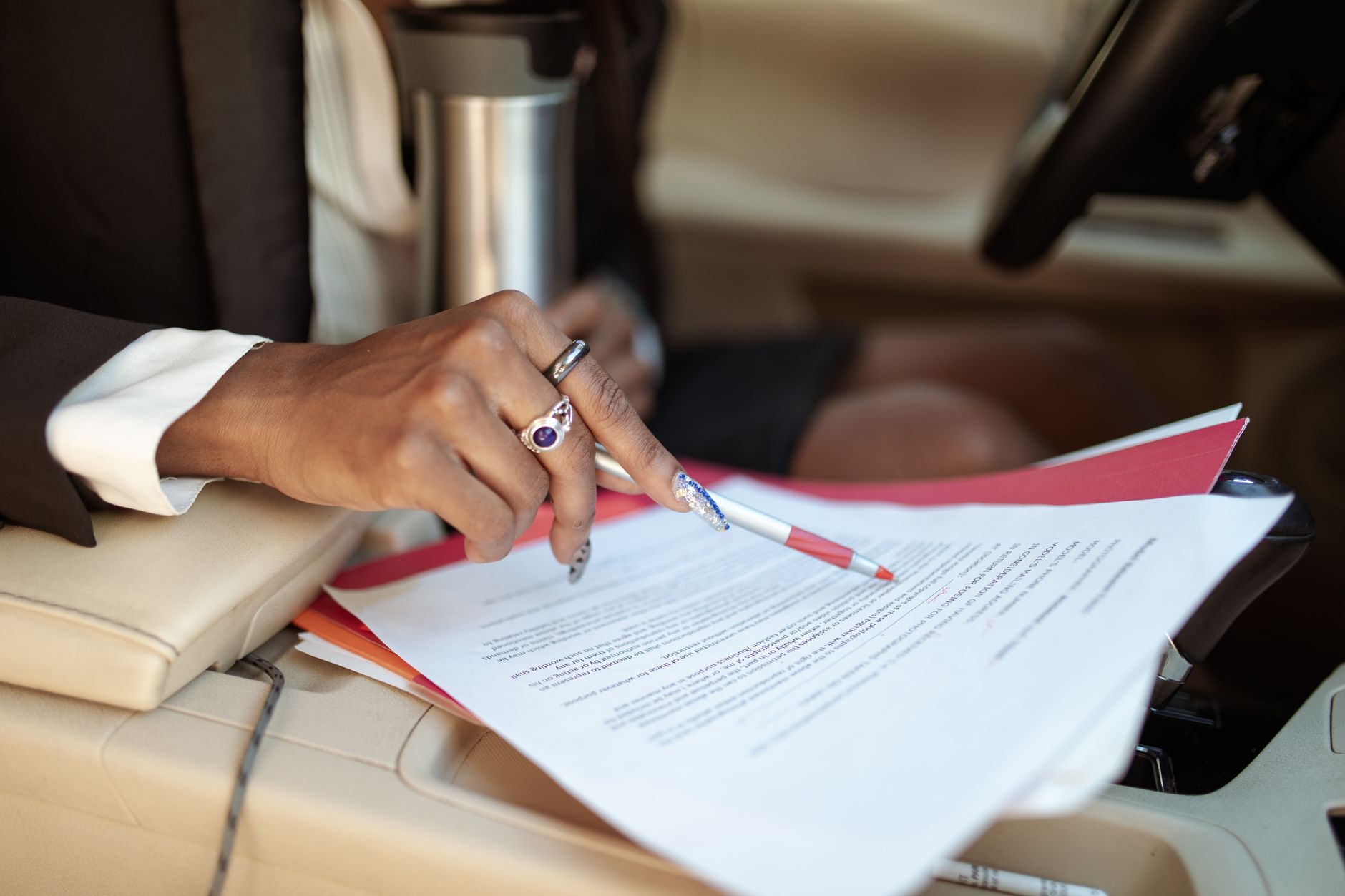 Pessoa analisando documentos de financiamento de carro atrasado sobre uma mesa