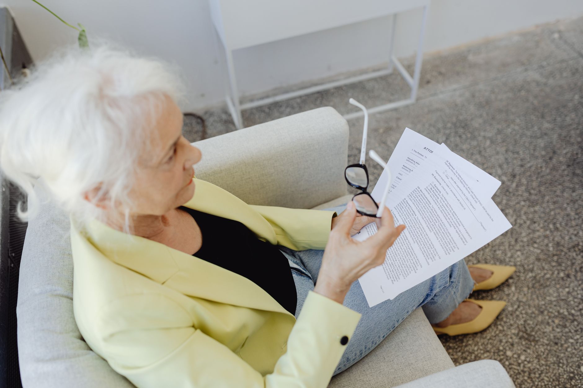 Pessoa idosa analisando documentos do benefício sobre uma mesa em casa.