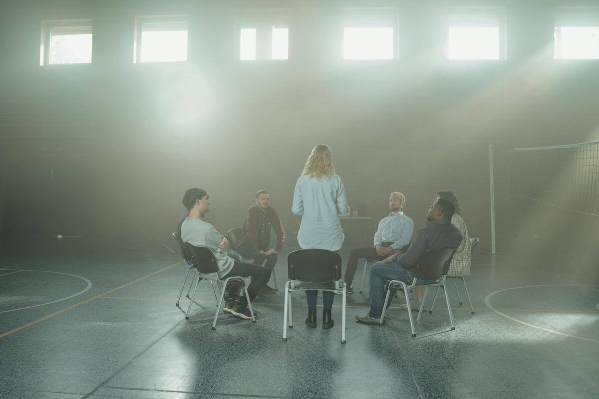 Plano para pagar as dívidas Grupo de apoio conversando sentado em roda numa sala iluminada
