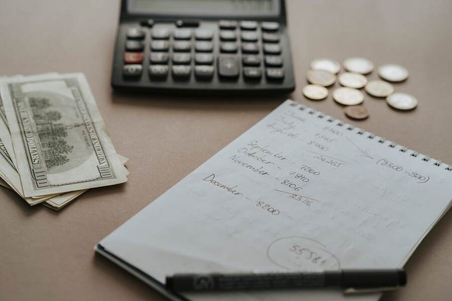 Calculadora e caderno para planejar as parcelas do empréstimo