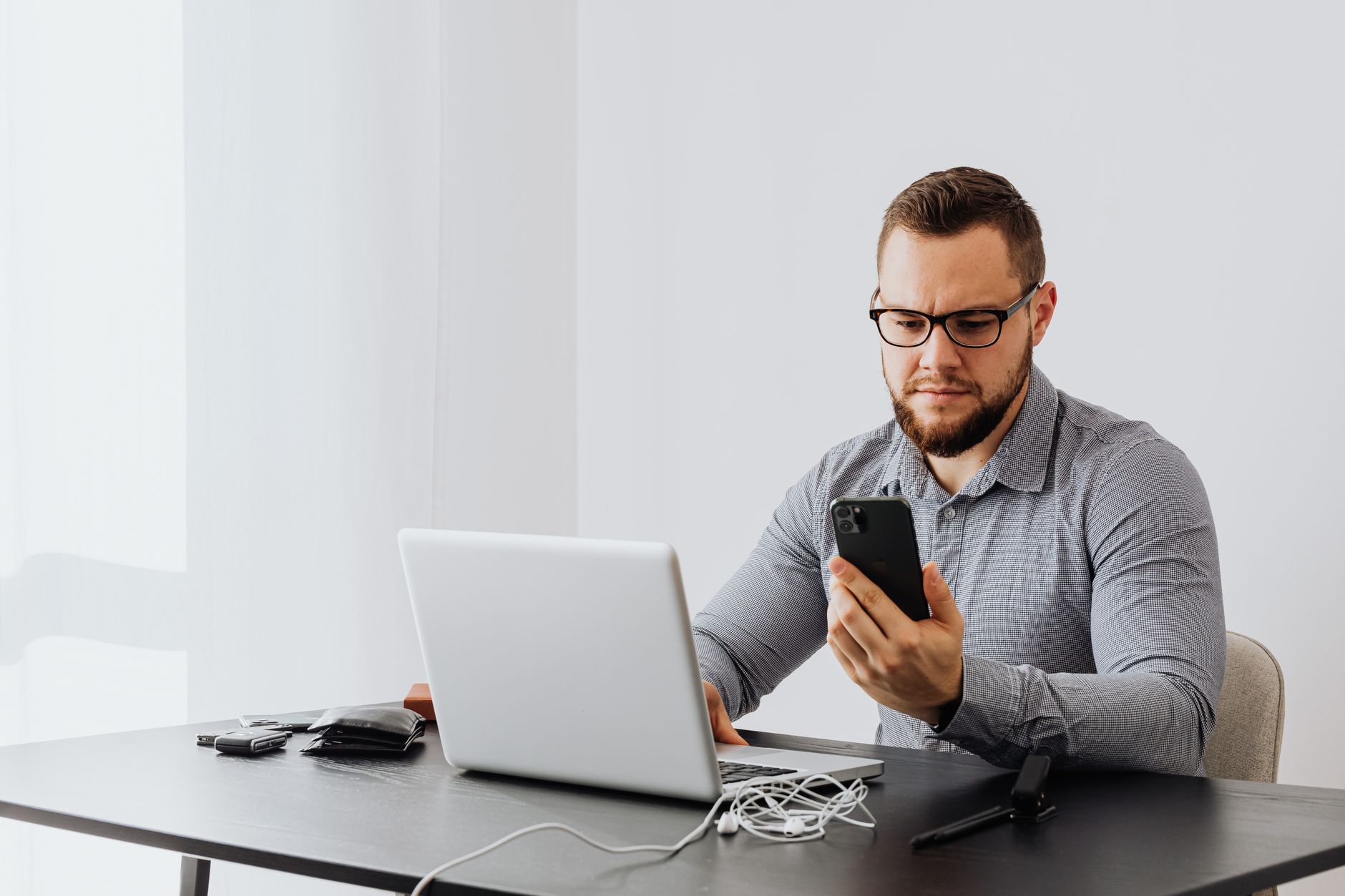 Empréstimo consignado para negativado: como funciona Professional man working at desk with laptop and smartphone, indoors.
