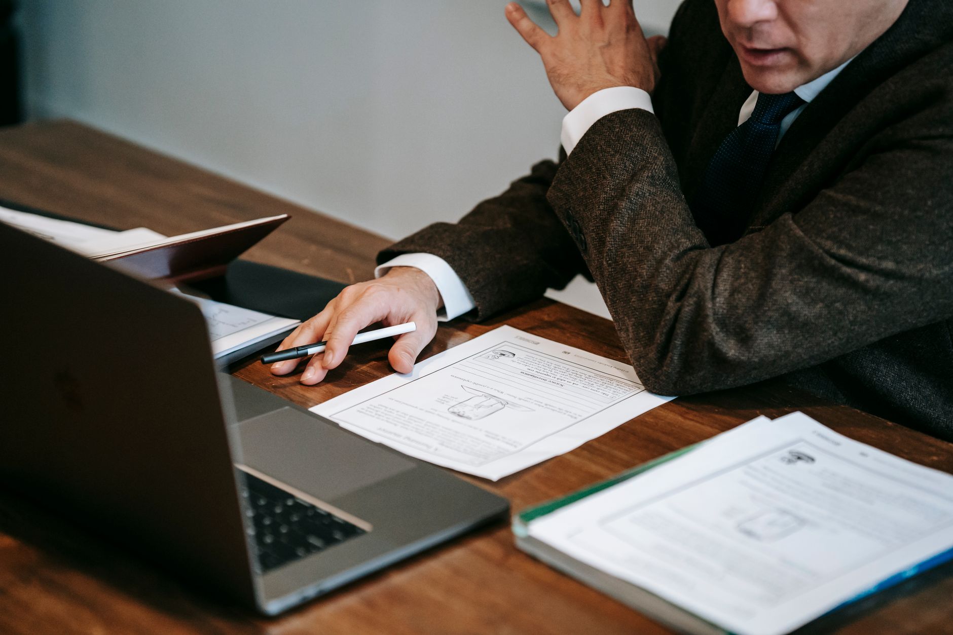Empréstimo para quem tem protesto em cartório: o que muda A business professional in formal attire analyzing documents and using a laptop for work indoors.